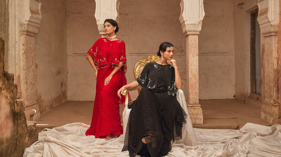 Woman wearing a cape-layered saree with elegant traditional drapes